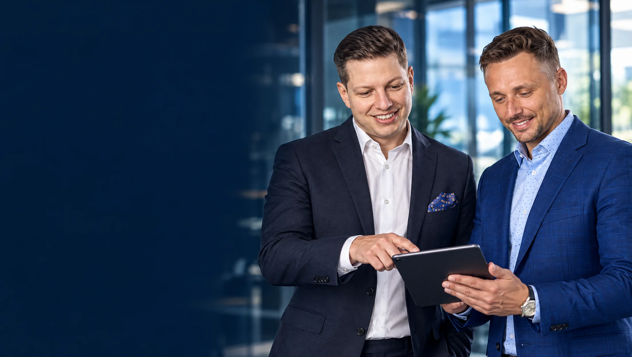 Marcin Moras i Sebastian Barnaś wspólnie analizują informacje na tablecie